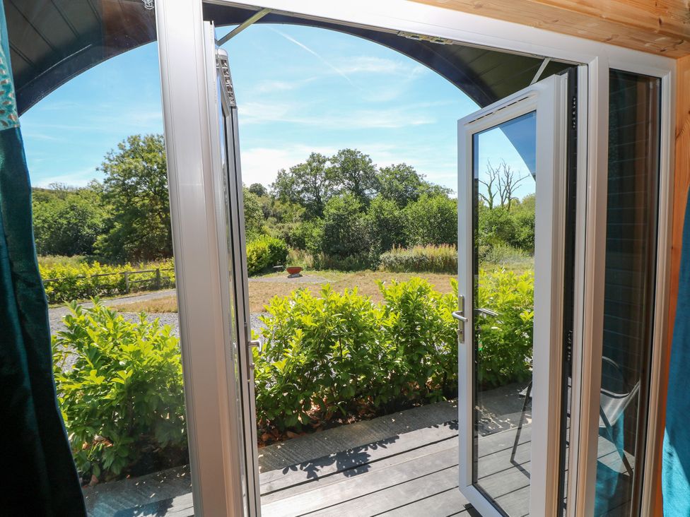 A view of a garden from an open door at Thelma’s Lodge near Pontyates