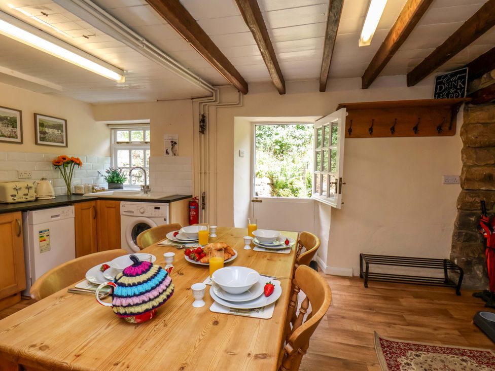 A kitchen with a dining table set for breakfast at 5 Hollins Cottages in Whitby