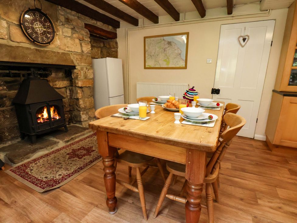 A dining room with a table set for breakfast at 5 Hollins Cottages in Whitby