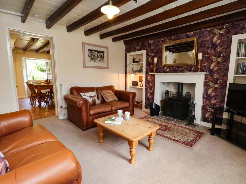 A living room with a sofa and fireplace at 5 Hollins Cottages in Whitby