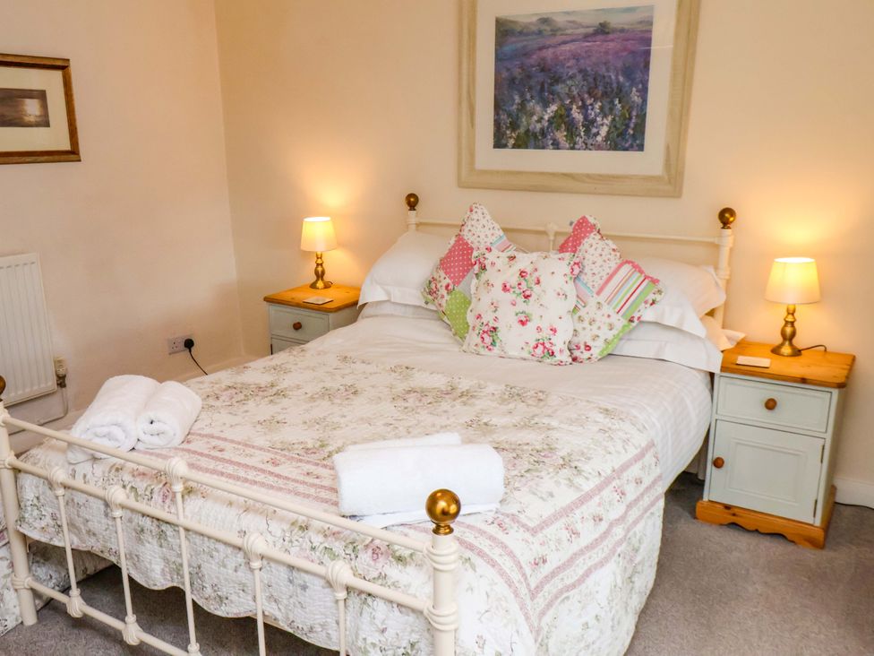 A bedroom with a bed and lamp at 5 Hollins Cottages in Whitby