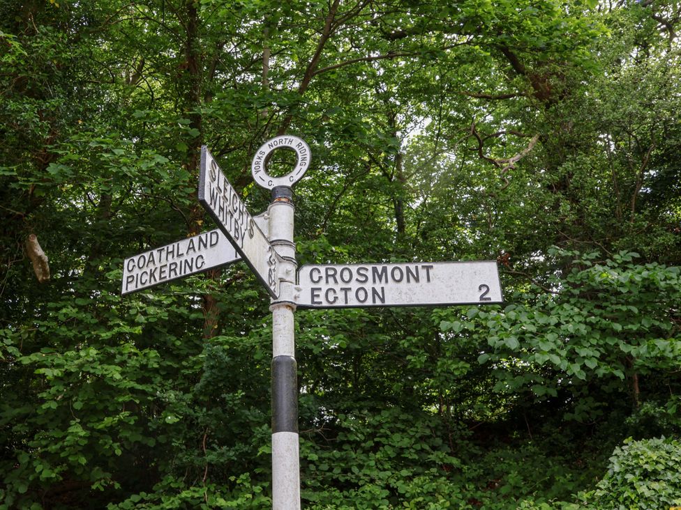 A signpost showing directions to various locations at 5 Hollins Cottages in Whitby