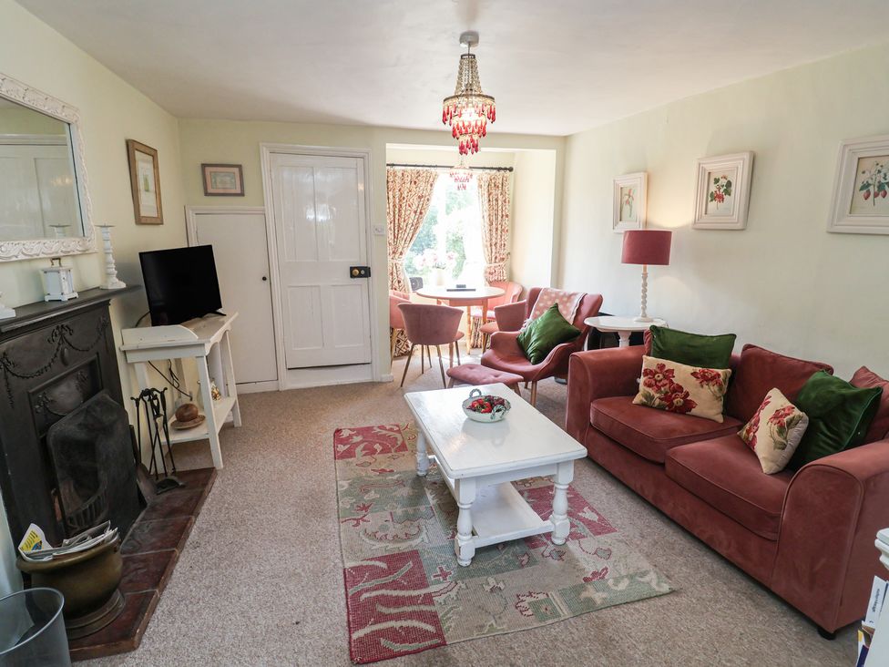 A living room with a sofa, coffee table, and television at Pebble in Blakeney, Norfolk