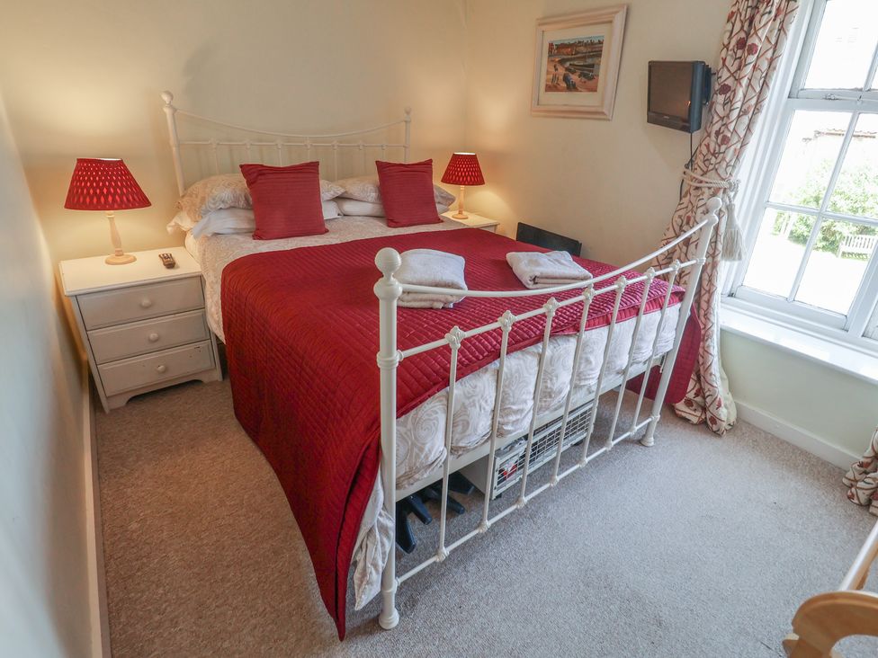 A bedroom with a bed and lamps at Pebble in Blakeney, Norfolk