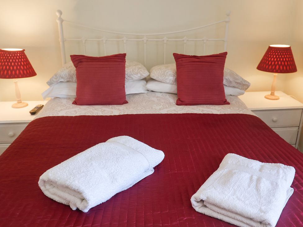 A bedroom with a bed and towels on the bed at Pebble, Blakeney, Norfolk