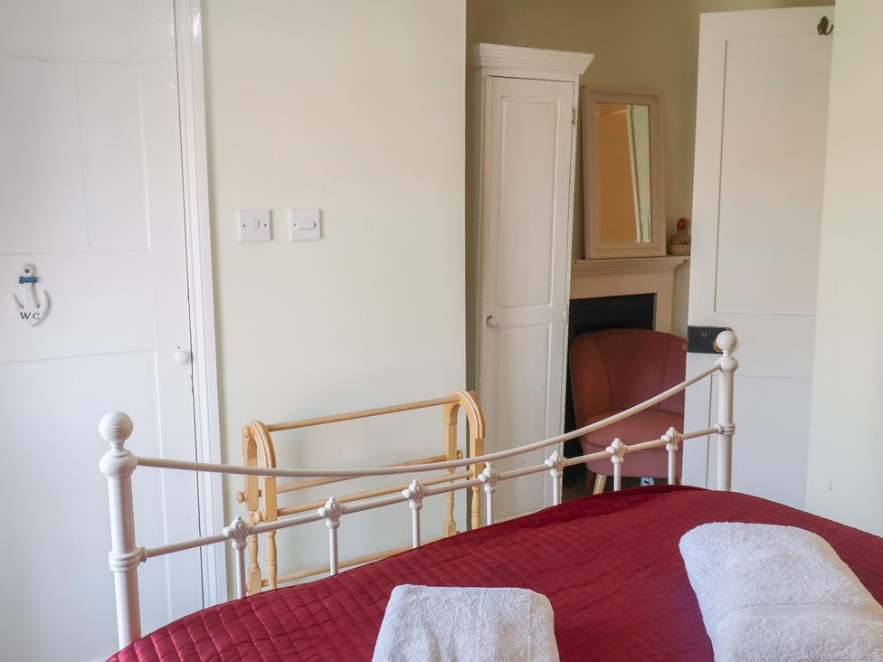A bedroom with a bed and wardrobe at Pebble in Blakeney, Norfolk