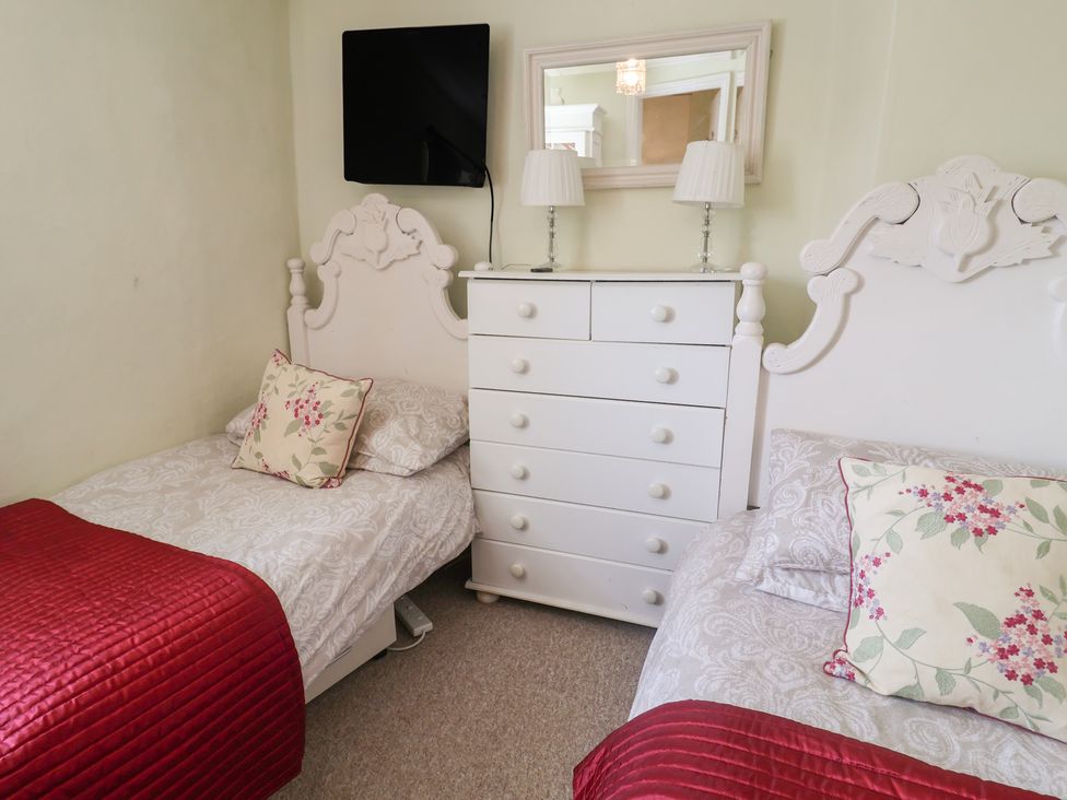 A bedroom with two single beds and a chest of drawers at Pebble in Blakeney, Norfolk