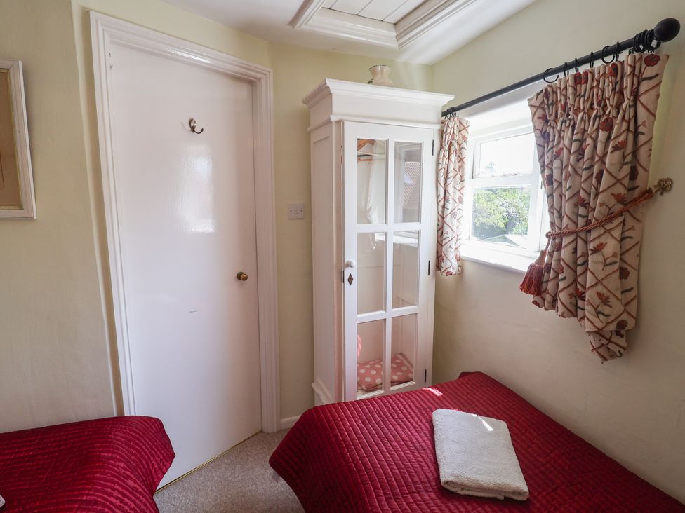 A bedroom with a bed and wardrobe at Pebble in Blakeney, Norfolk