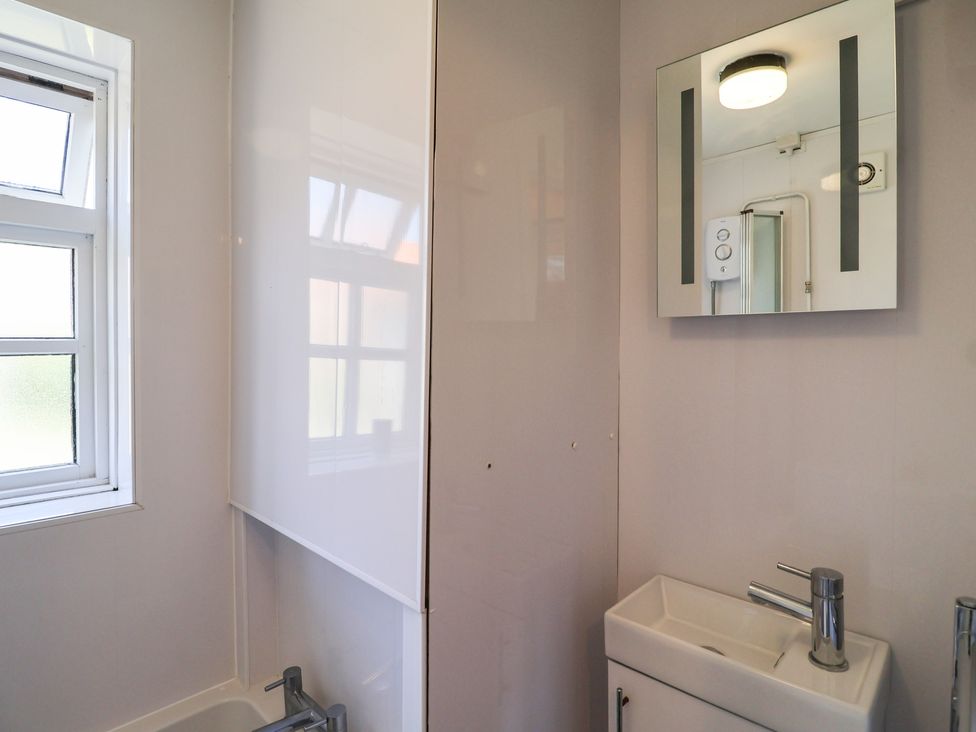 A bathroom with a sink and shower at Pebble in Blakeney, Norfolk