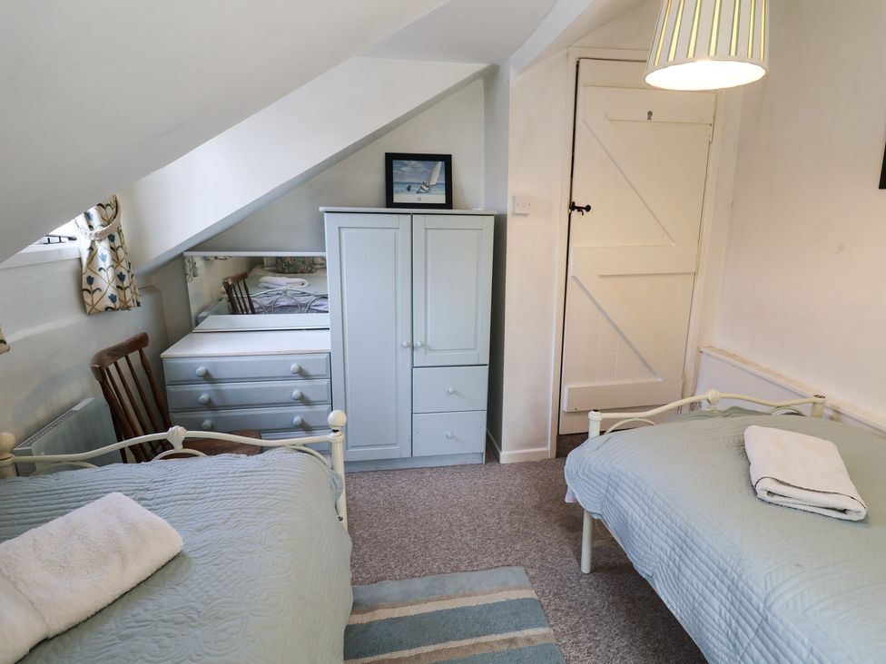 A bedroom with two beds and a dresser at Buttercup in Blakeney, Norfolk