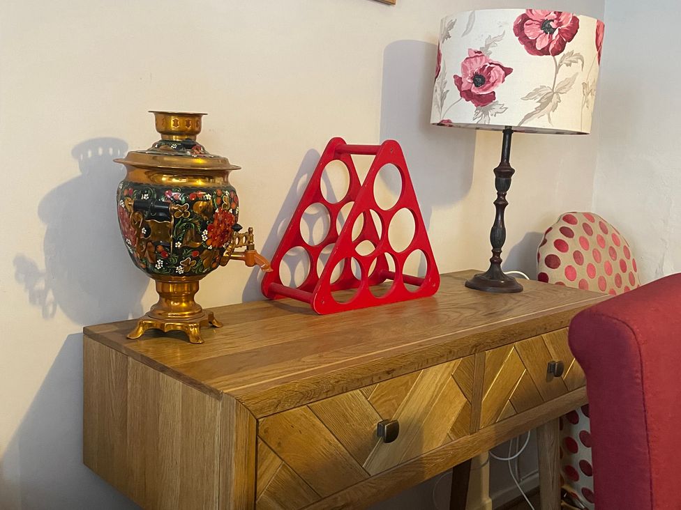 A table with a lamp and decorative items in a living room at The Bittern in Blakeney, Norfolk
