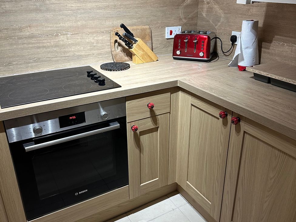 A kitchen with an oven, cooktop, toaster, and knife block at The Bittern in Blakeney, Norfolk