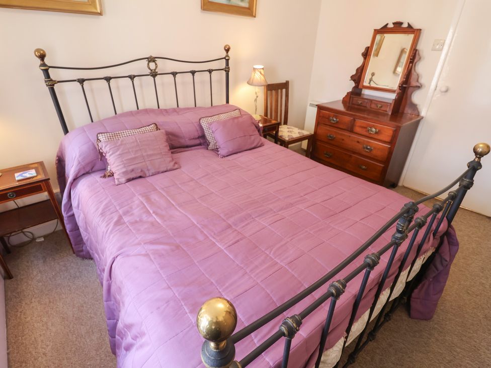 A bedroom with a bed and wooden furniture at The Plover in Blakeney, Norfolk