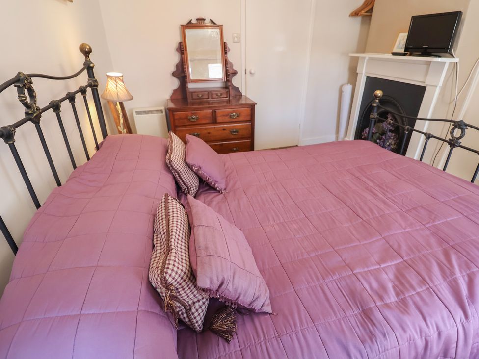 A bedroom with a bed and dresser at The Plover in Blakeney, Norfolk