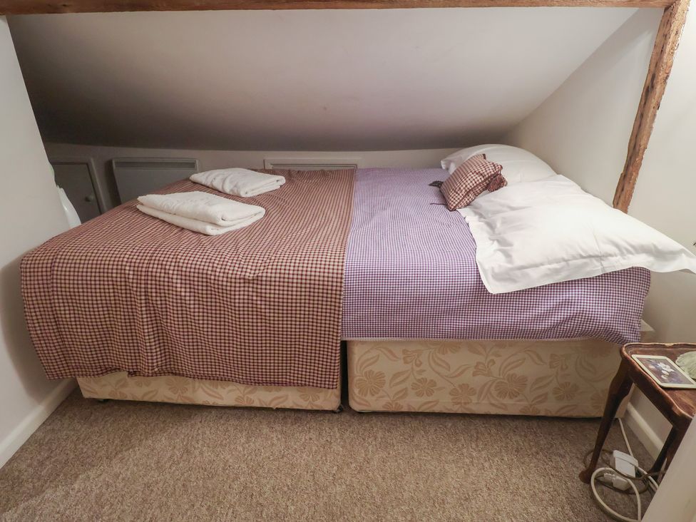 A bedroom with two beds and towels at The Plover in Blakeney, Norfolk