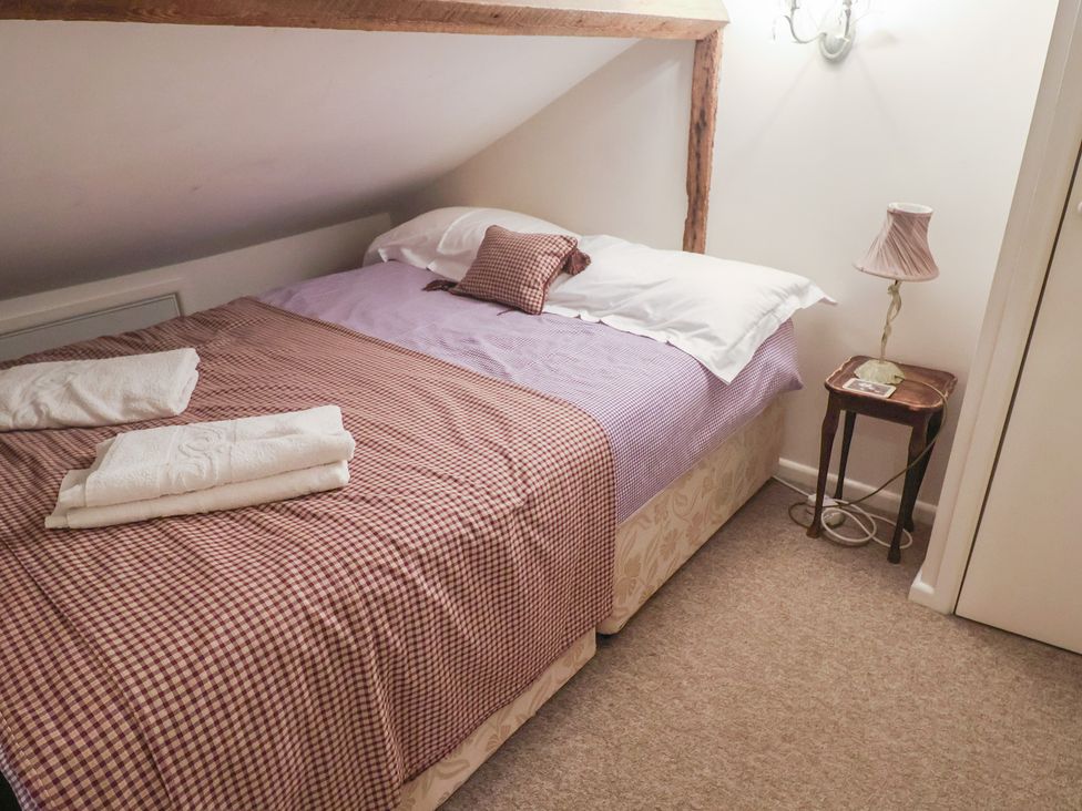 A bedroom with a bed and bedside table at The Plover in Blakeney, Norfolk