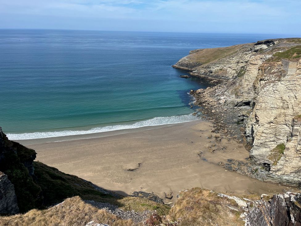 A beach with cliffs and sea at The Hideaway in Tintagel