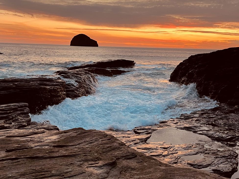 A seascape with waves and rock formations during sunset at The Hideaway in Tintagel