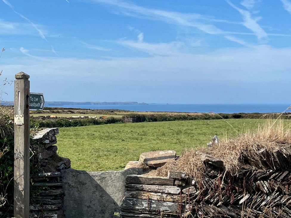 A view of the ocean and grass fields from a signpost at The Hideaway in Tintagel