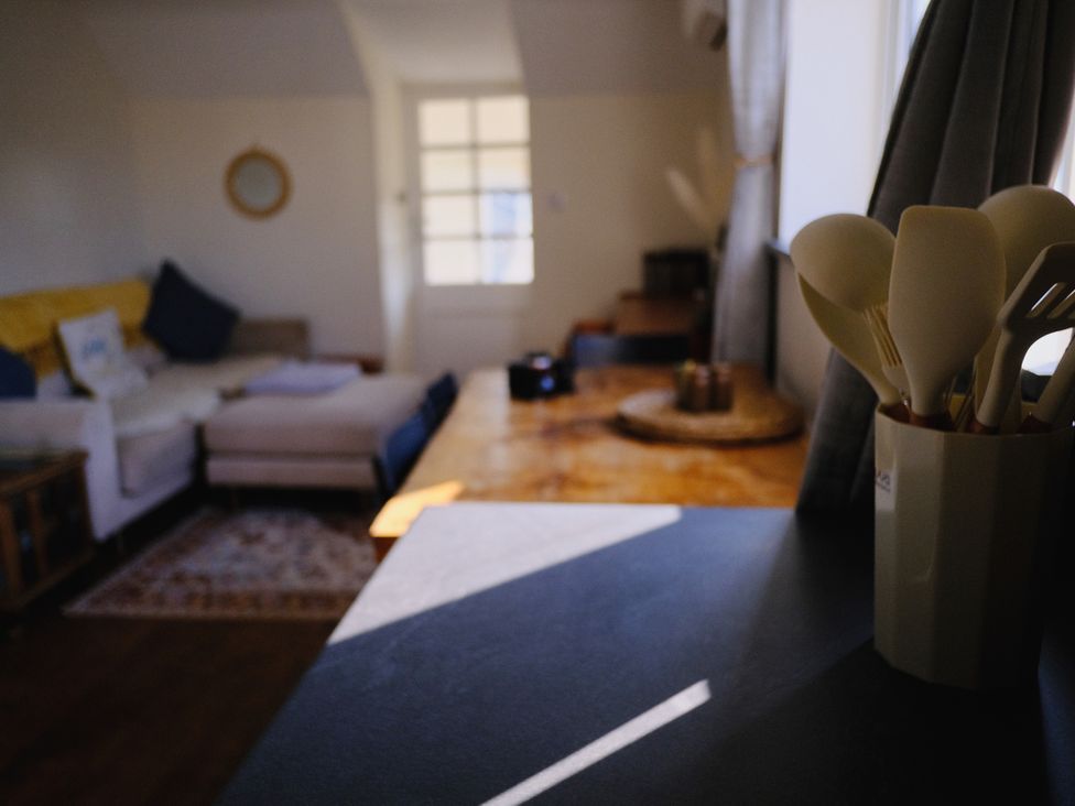 A living room with a sofa and utensils on the table at The Hideaway in Tintagel