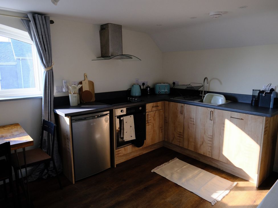 A kitchen with appliances and cabinetry at The Hideaway in Tintagel