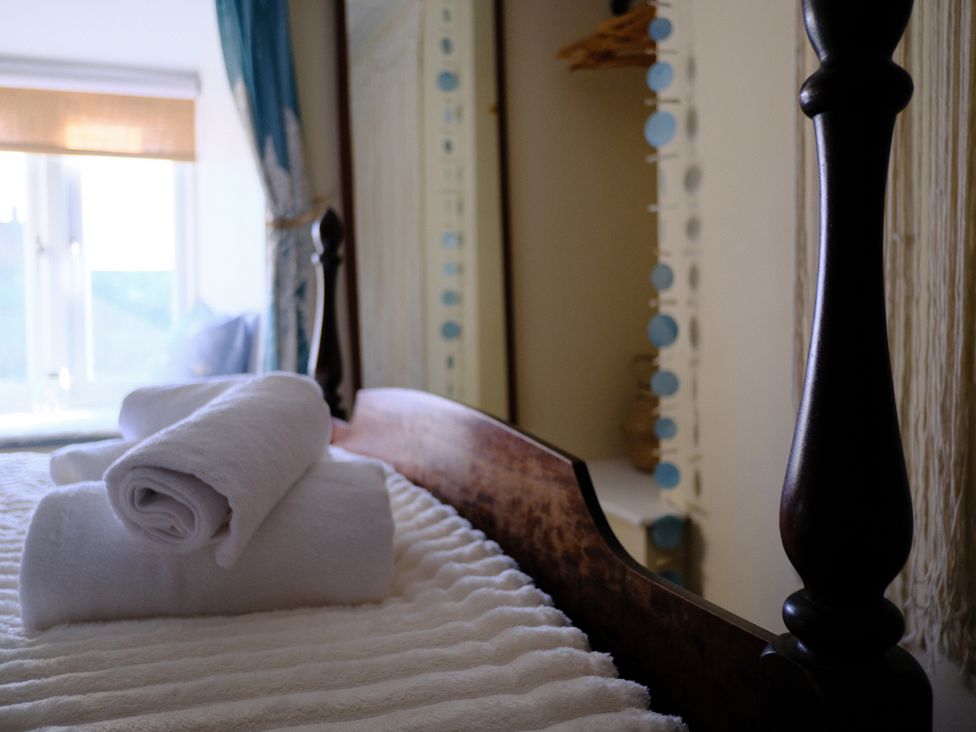 A bedroom with towels on a bed at The Hideaway in Tintagel