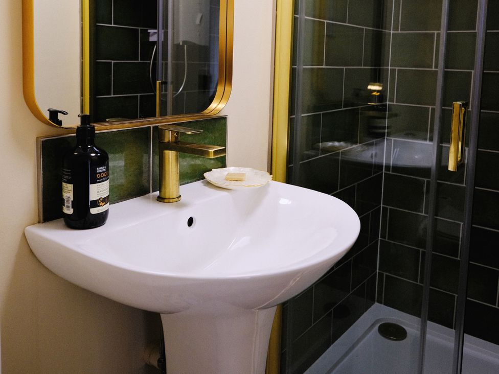 A sink and mirror in a bathroom at The Hideaway in Tintagel