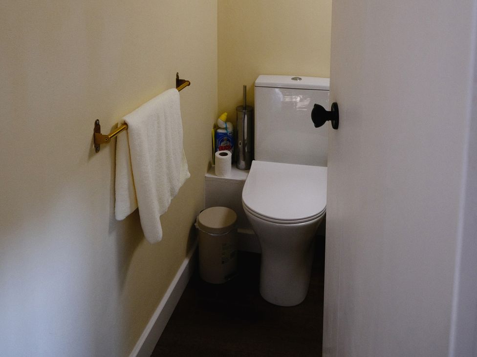 A bathroom with a toilet and towel rack at The Hideaway in Tintagel
