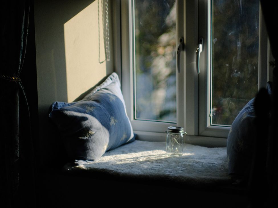 A window with cushions and a jar on the sill at The Hideaway in Tintagel