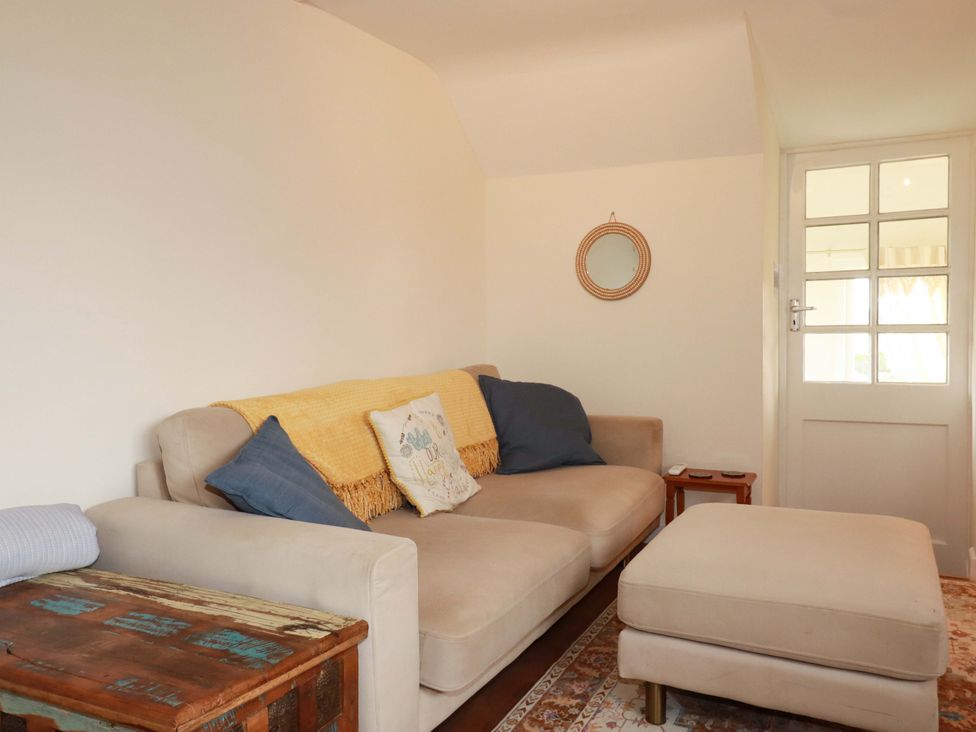 A living room with a sofa and table at The Hideaway in Tintagel