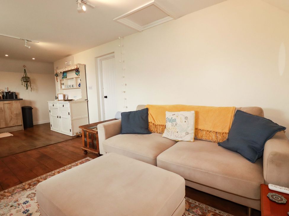 A living room with a sofa and a shelf at The Hideaway in Tintagel