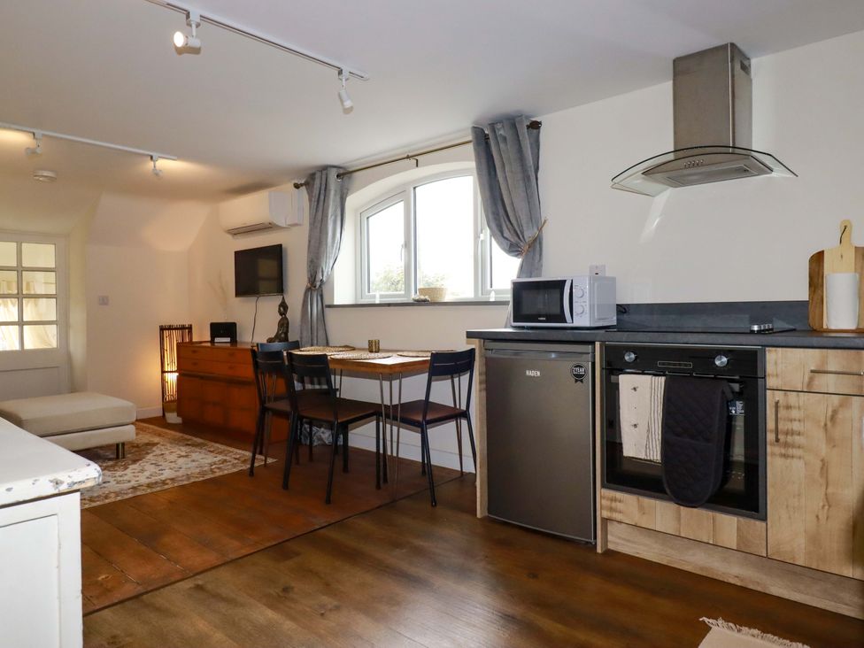 A kitchen with modern appliances and furniture at The Hideaway in Tintagel