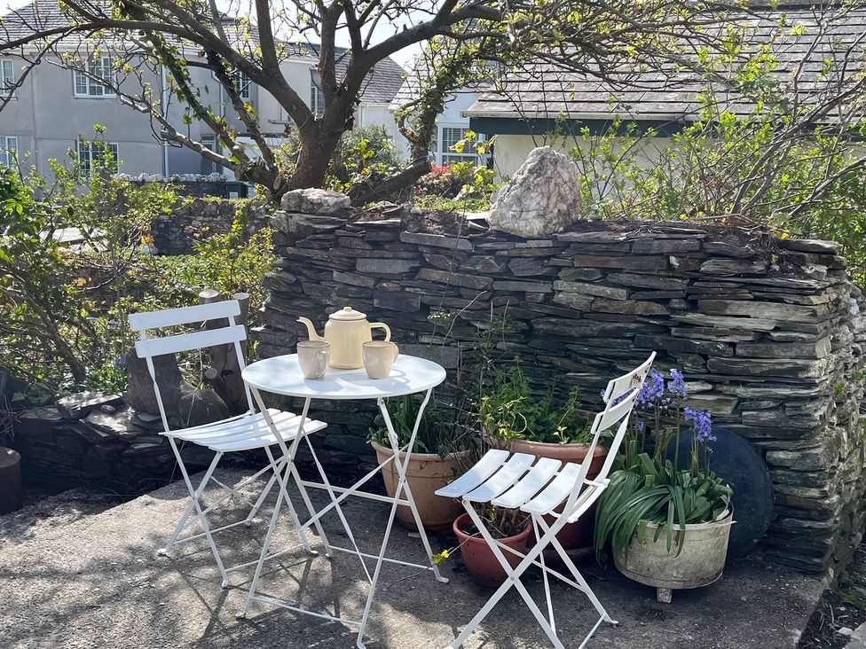 An outdoor seating area with a table and chairs at The Hideaway in Tintagel