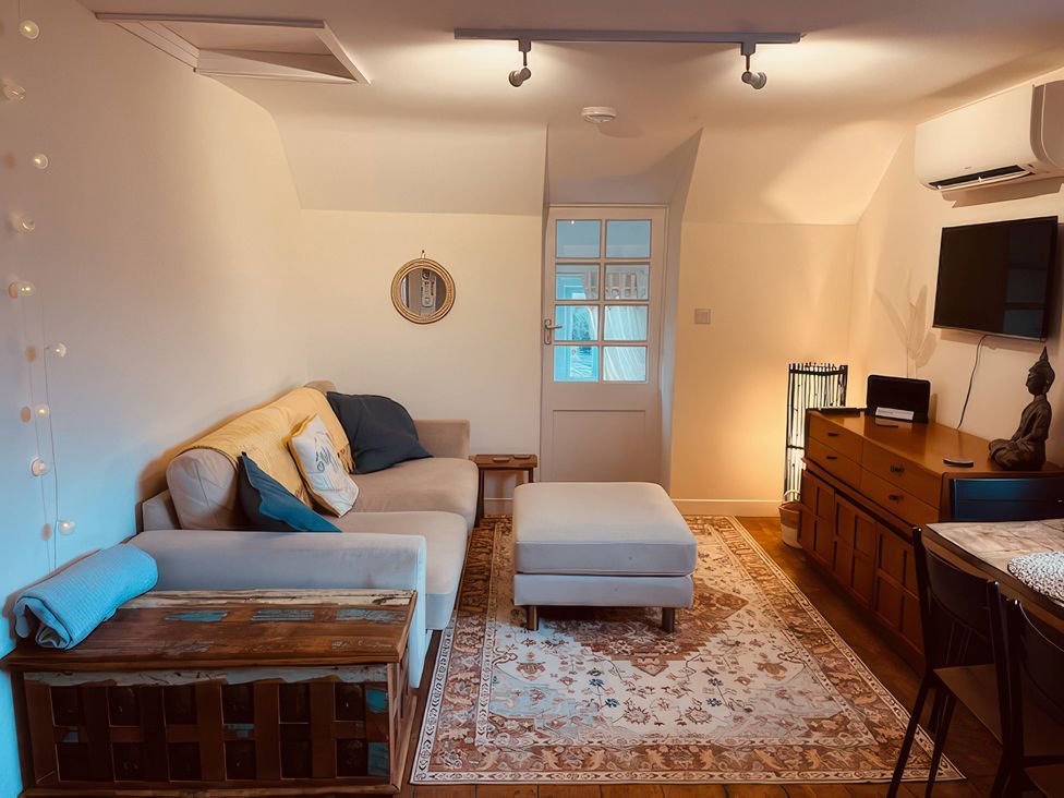 A living room with a sofa and television at The Hideaway in Tintagel