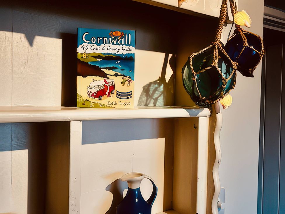 A shelf with a book and decorative items at The Hideaway in Tintagel