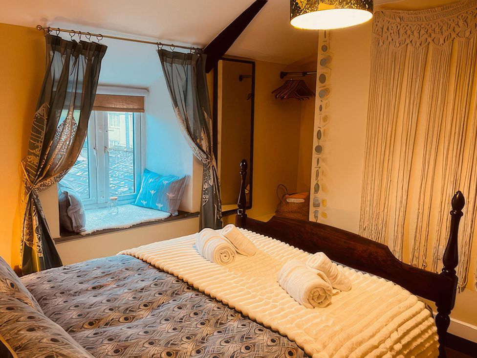 A bedroom with a bed and towels on it at The Hideaway in Tintagel