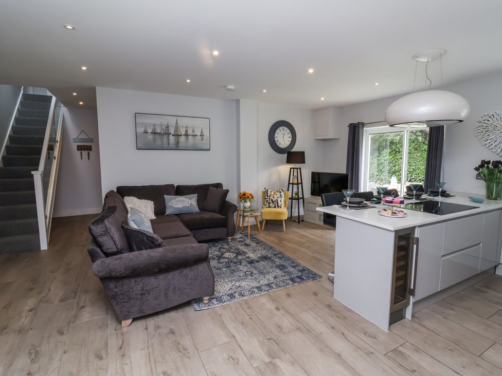A living room with a sofa and kitchen island at Beach Hideaway