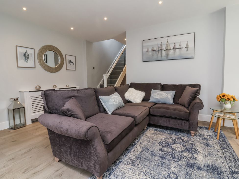 A living room with a sofa and carpet at Beach Hideaway
