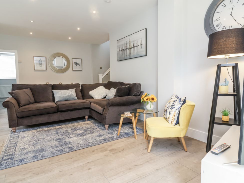 A living room with a sofa and side table at Beach Hideaway