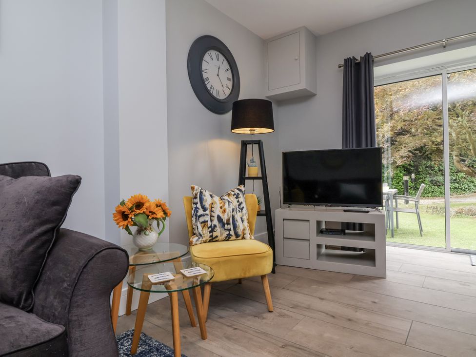 A living room with a television and a sofa at Beach Hideaway