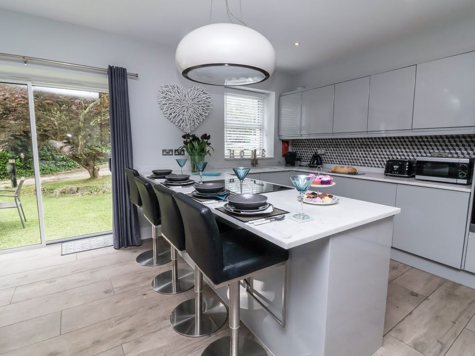 A kitchen with bar stools and countertop at Beach Hideaway