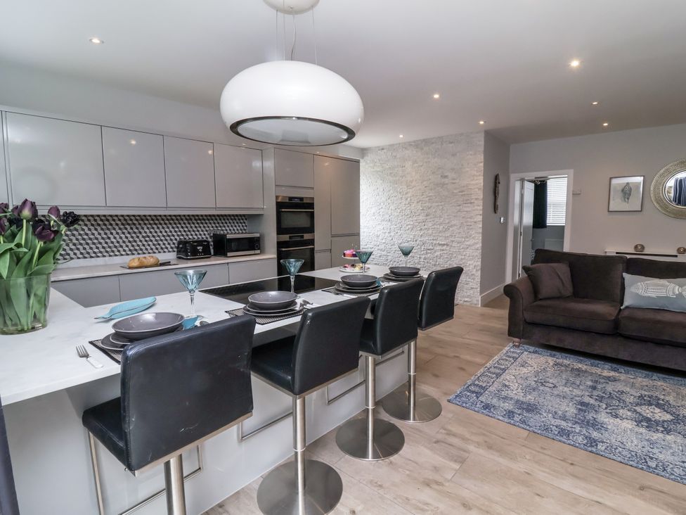 A kitchen with bar stools and a dining area at Beach Hideaway