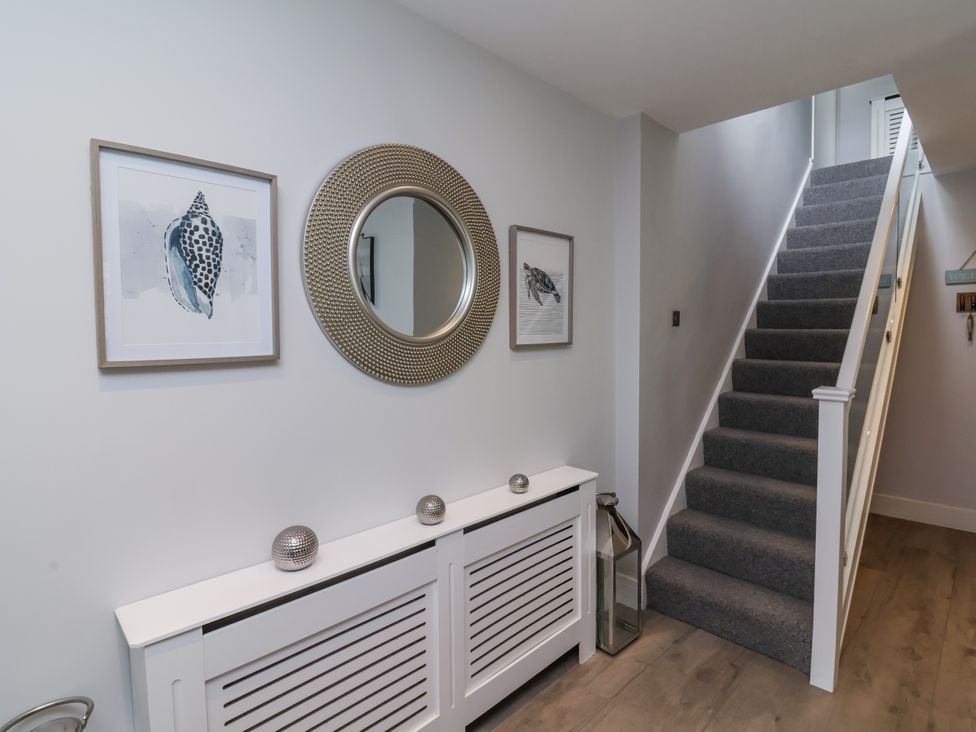 A hallway with a staircase and wall art at Beach Hideaway 