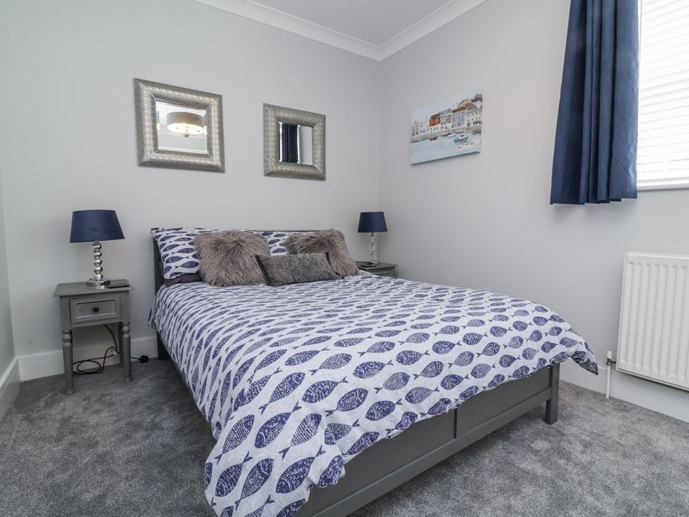 A bedroom with a bed and bedside table at Beach Hideaway 