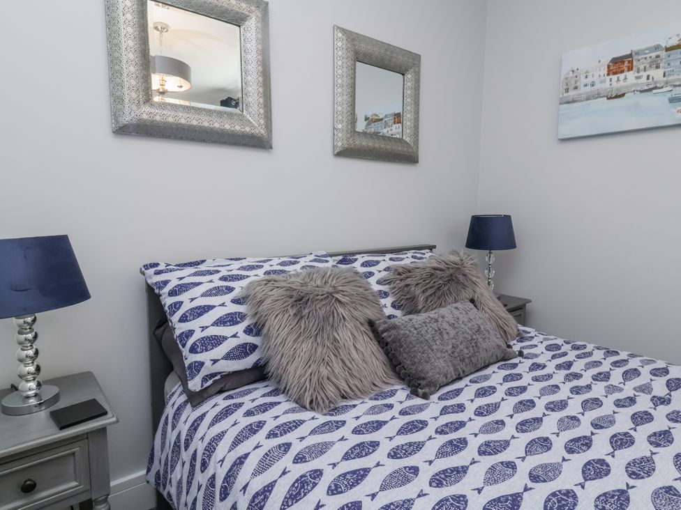 A bedroom with a bed and mirrors at Beach Hideaway
