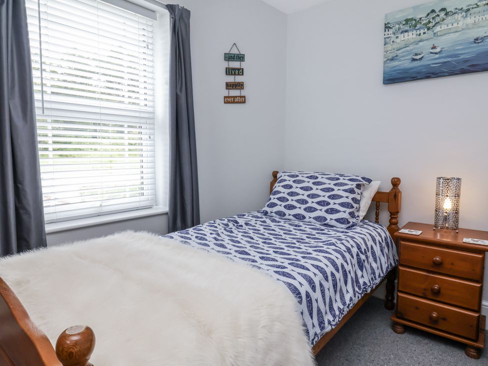 A bedroom with a single bed and nightstand at Beach Hideaway