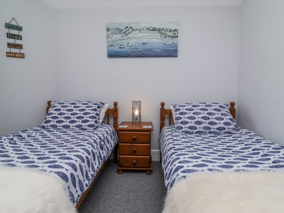 A bedroom with two beds and a lamp on a nightstand at Beach Hideaway