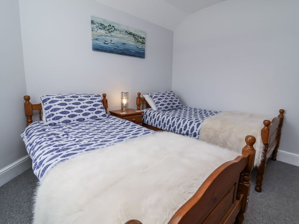 A bedroom with two single beds and a nightstand at Beach Hideaway
