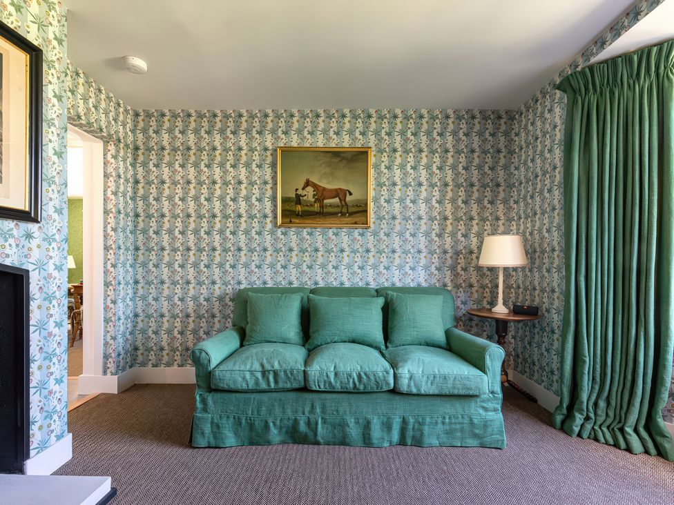 A living room with a sofa and painting at Dairy Cottage Waddeston