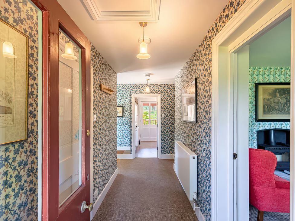 A hallway with a door and light fixtures at Dairy Cottage in Waddeston